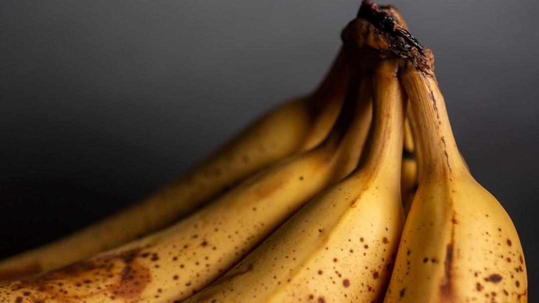 Rijpe bananen tegen grijze achtergrond