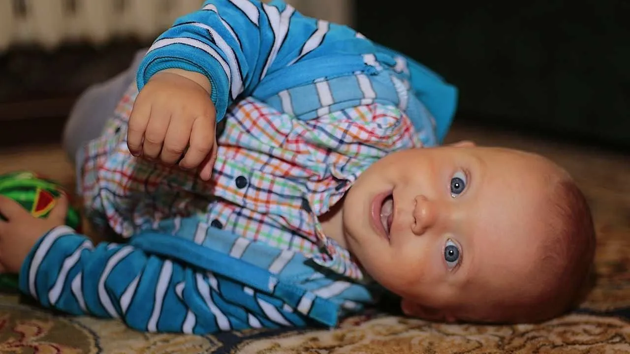 Lachende baby op tapijt, vooraanzicht