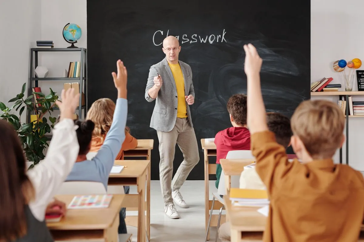 Leraar voor het schoolbord met leerlingen die hun vinger opsteken