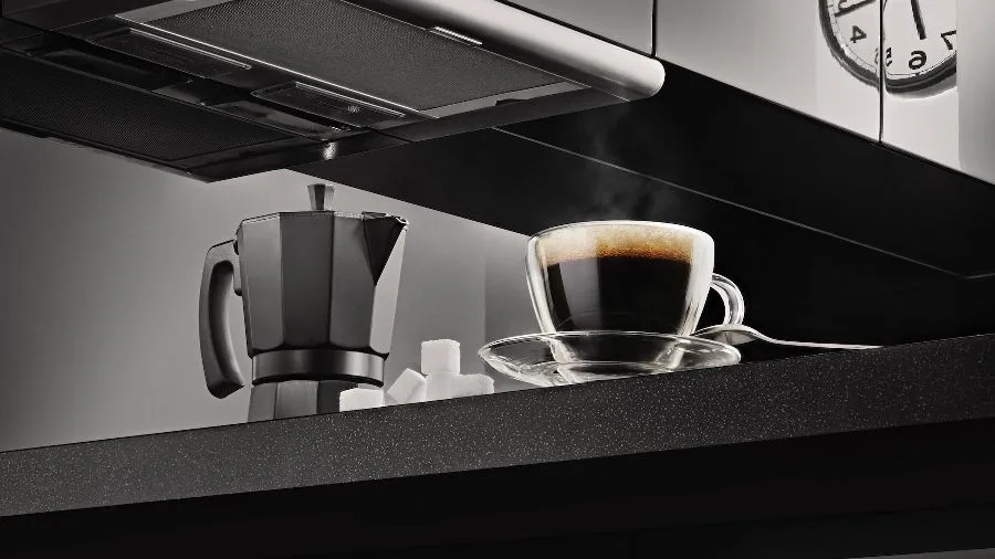 Kopje koffie met percolator op aanrecht