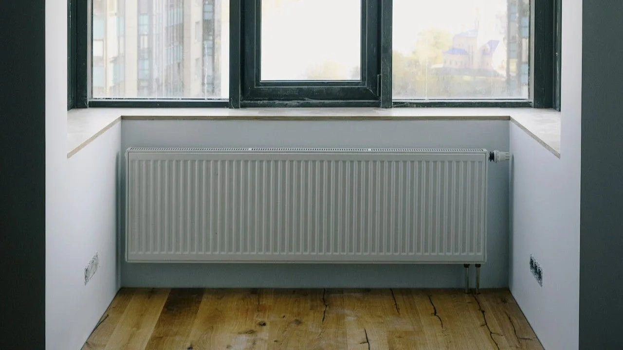Witte radiator onder het raam